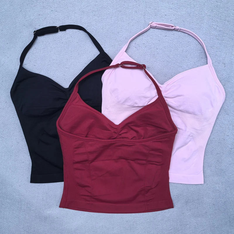 Three tank tops in black, red, and pink on a light blue background