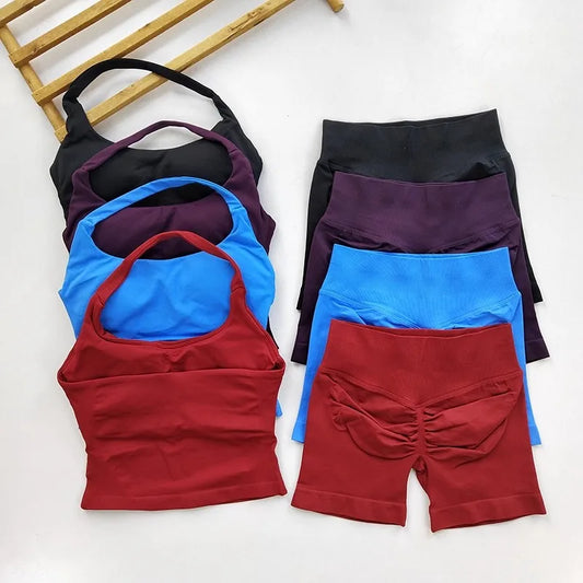 Set of sports bras and shorts in black, blue, and red on a white background
