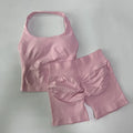 Pink sports bra and shorts set on a light gray background