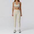 Person wearing a beige sports bra and leggings set on a white background