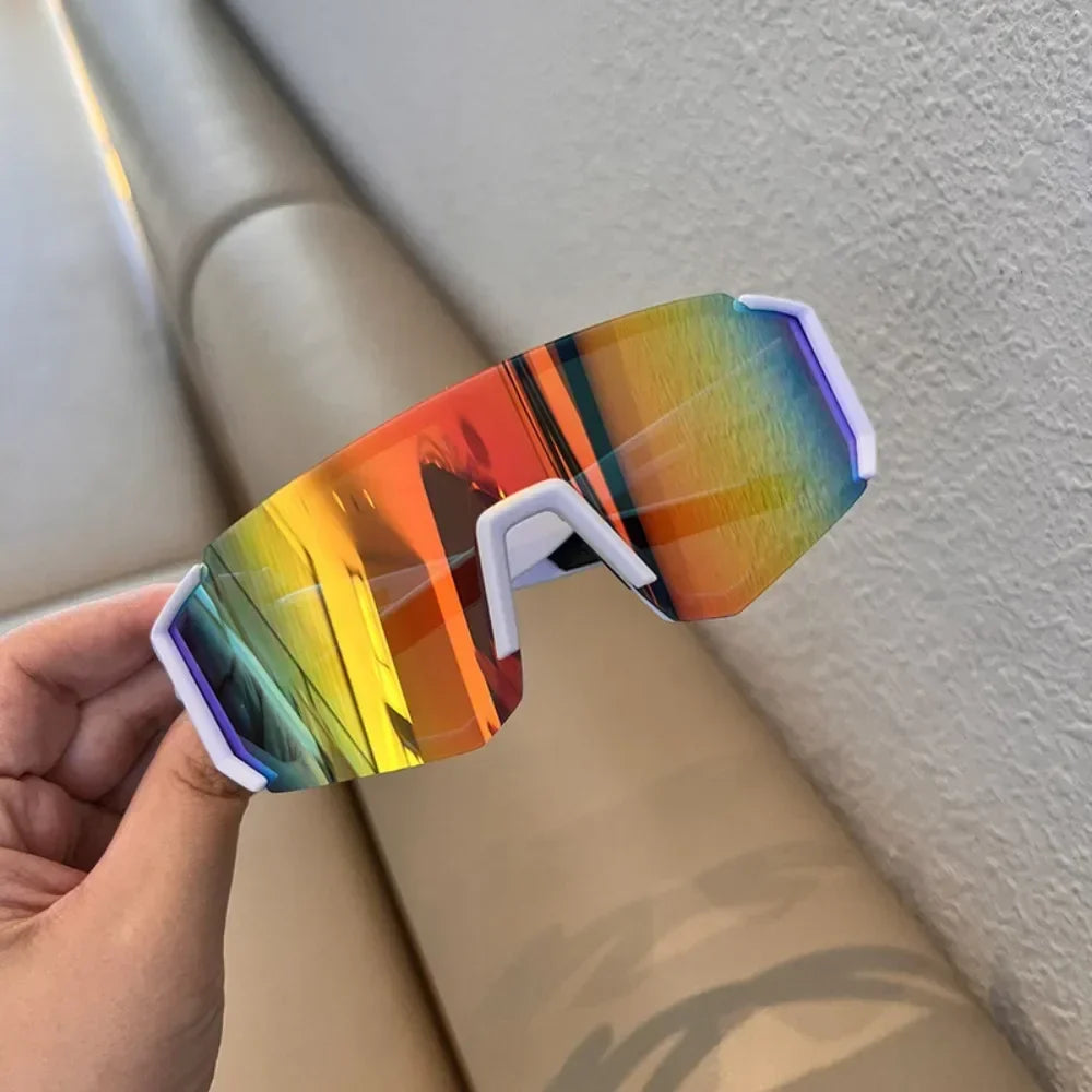 Sunglasses with colorful reflective lenses held by a hand against a neutral background